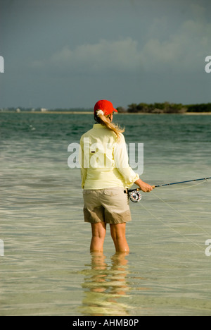 Florida Keys donna colata del pescatore di Bonefish mentre la pesca con la mosca gli appartamenti dell'oceano dei Caraibi Foto Stock