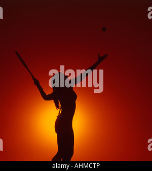 Ragazza giocatore di tennis si prepara a servire la palla in silhouette golden view Foto Stock