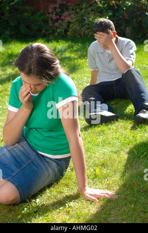 Coppia adolescenti seduti insieme nel parco avente un argomento e lotta Foto Stock