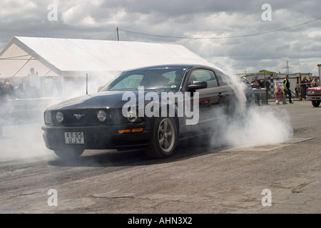 Fine del modello Ford Mustang facendo burnout a Melbourne canalina North Yorkshire, Inghilterra Foto Stock