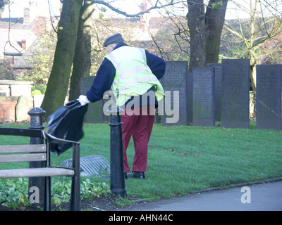 Consiglio operaio la raccolta di rifiuti in un cimitero. Foto Stock