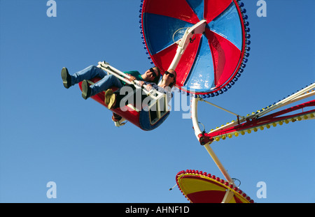 Due giovani donne ragazze ridere godendo giostra luna park ride in villeggiatura estiva di Brighton, Inghilterra. Foto Stock