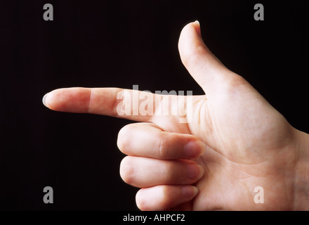 La mano con il dito puntato contro uno sfondo scuro Foto Stock