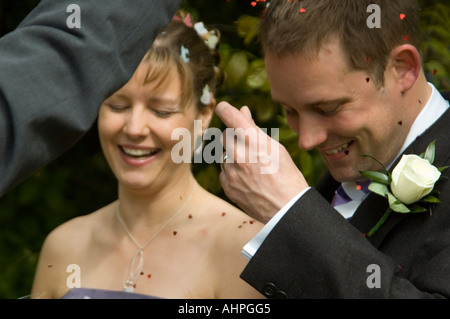 Ritratto orizzontale del felice sposa e lo sposo avente coriandoli gettati a loro Foto Stock