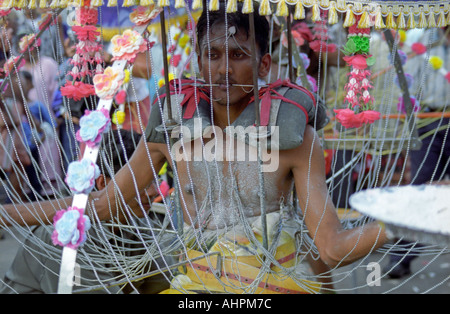 Thaipusam devoto portante un kavadi e poggiante su una sedia vicino Grotte Batu Kuala Lumpur in Malesia a sud est asiatico Foto Stock