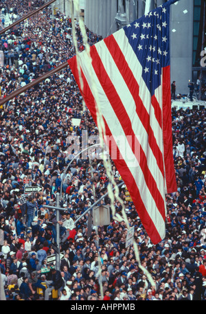 Bandiera americana volando sopra la grande folla a tickertape Parade New York Foto Stock