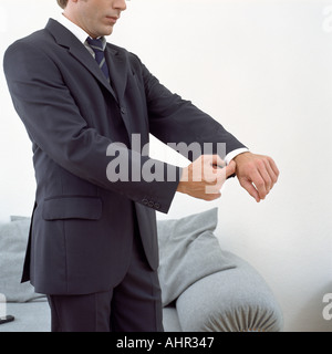 L'uomo la sua regolazione polsi Foto Stock