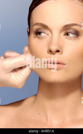 Chirurgo tirando donna di pelle Foto Stock