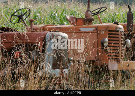 Due abbandonare rusty trattori agricoli nel lungo erba secca Foto Stock