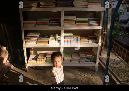 Piccolo Ragazzo passeggiate display del passato nel negozio di vendita carta a mano e nota libri a Luang Prabang, Laos Foto Stock