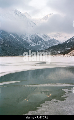 Il lago Akkem parzialmente coperto con ghiaccio e la cima più alta della Siberia la montagna Belukha sullo sfondo Altai Russia Foto Stock