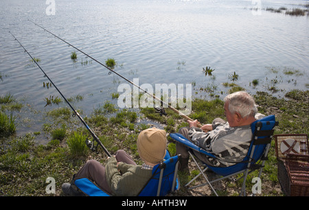 Nonno e nipote (12-14) la pesca di fiume, vista posteriore Foto Stock
