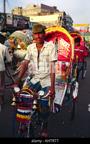 Bicicletta colorata risciò e autista sulle strade trafficate di Dhaka. Bangladesh Foto Stock