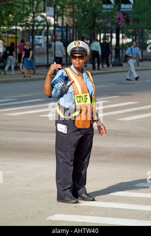 La polizia del traffico pedonale diretto e il traffico automobilistico nella trafficata downtown Chicago Illinois Foto Stock