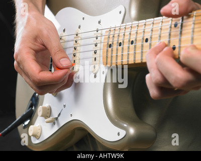 Una chitarra elettrica player close up sulle mani. Foto Stock