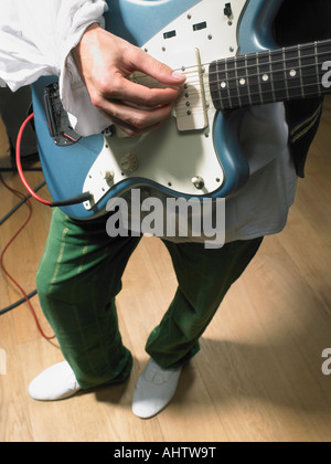 Una chitarra elettrica player chiudere fino a portata di mano in studio. Foto Stock