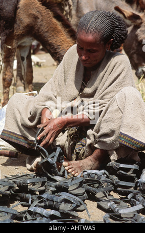 La donna la realizzazione e la vendita di sandali realizzati da vecchi pneumatici. Mahoney,Tigray, Etiopia Foto Stock