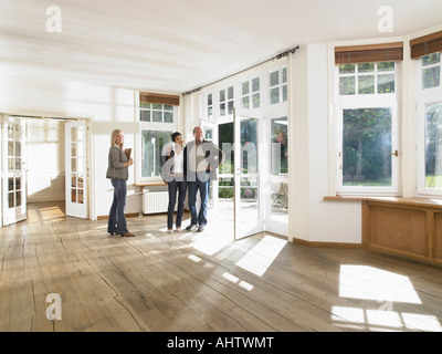 Agente immobiliare che mostra casa vuota per un paio. Ampio angolo. Foto Stock