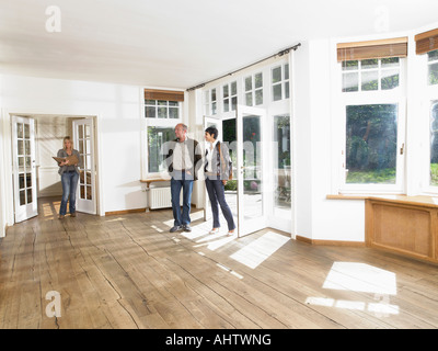 Agente immobiliare che mostra casa vuota per un paio. Foto Stock