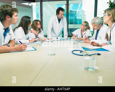 Incontro di lavoro di un gruppo di medici in una sala conferenze intorno a un tavolo. Foto Stock
