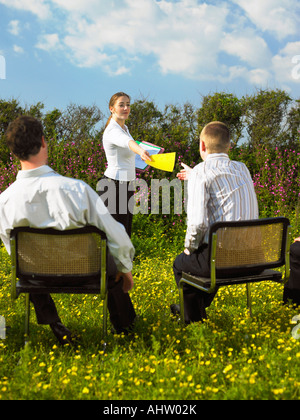 Gruppo di imprenditori seduti su sedie in campo. Foto Stock