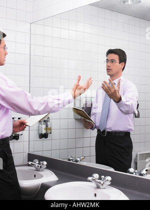 L'uomo la pratica di discorso in ufficio Specchio bagno Foto Stock