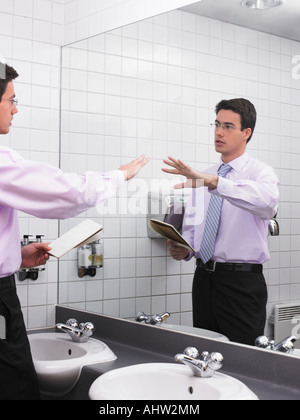 L'uomo la pratica di discorso in ufficio Specchio bagno Foto Stock