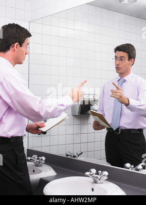 L'uomo la pratica di discorso in ufficio Specchio bagno Foto Stock