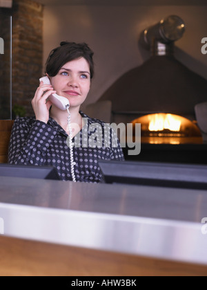 Hostess presso la sua stazione in un ristorante Foto Stock