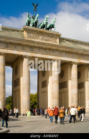 Vista verticale della Porta di Brandeburgo sulla Pariser Platz con i turisti in gita su una luminosa giornata di sole. Foto Stock