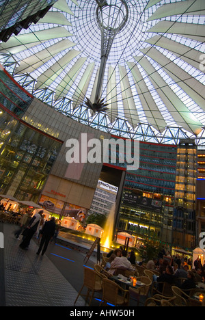 Verticale ampia angolazione della spettacolare atrio centrale di Helmut Jahn con la creazione del Centro Sony trafficata con un sacco di persone. Foto Stock