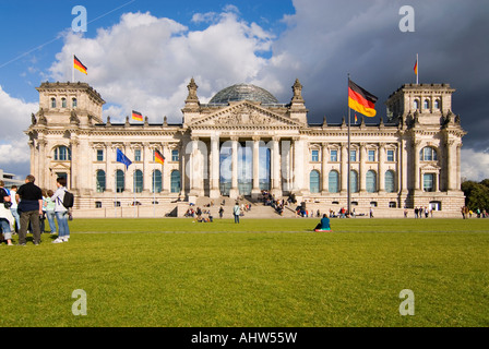 Orizzontale di ampio angolo di turisti sull'erba al di fuori del Reichstag a Platz de Repubblica in una bella giornata di sole. Foto Stock