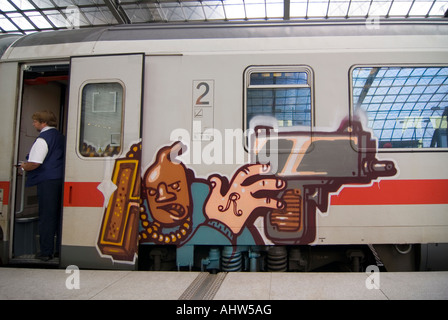 Chiudere orizzontale su di un treno InterCity carro coperto di graffiti in attesa su una piattaforma a Berlin Hauptbahnhof. Foto Stock