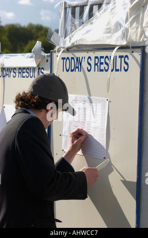 L'uomo la scrittura di canottaggio risultati di gara sulla bacheca durante Henley Royal Regatta Oxfordshire England Regno Unito Foto Stock