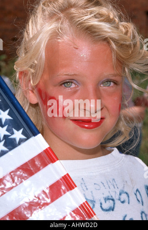 8 anno femmina vecchia raffigura un tema patriottico con una bandiera e faccia dipinta Foto Stock