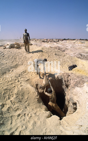 Artigianale di Gold Miner passando le buste di minerale di oro per co-lavoratore presso Essakane goldfields, Burkina Faso, Africa occidentale Foto Stock