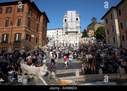 Guardando verso l'alto dalla Piazza di Spagna sulla folla di turisti e gente del posto per la scalinata di piazza di Spagna con la fontana verso Trinita dei Monti Foto Stock