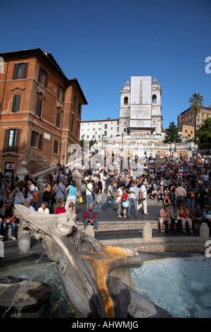 Guardando verso l'alto dalla Piazza di Spagna sulla folla di turisti e gente del posto per la scalinata di piazza di Spagna con la fontana verso Trinita dei Monti Foto Stock