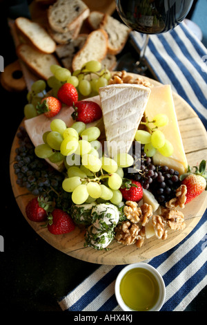 Il piatto di formaggi, un vassoio di frutta fresca, party, vino rosso, vino bianco, uva secca di Corinto, fragole, frutta fresca, olio d'oliva Foto Stock