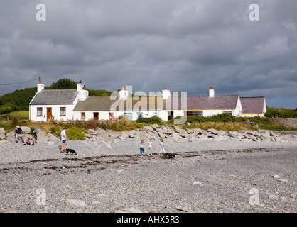 Fila di casette bianche accanto all isola di Anglesey sentiero costiero intorno piccola baia sulla costa nord-est. Moelfre Anglesey North Wales UK Foto Stock