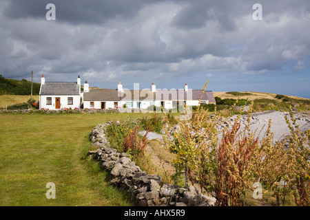 Riga bianca di case di pescatori accanto all isola di Anglesey sentiero costiero sulla costa nord est AONB. Moelfre Anglesey North Wales UK Foto Stock