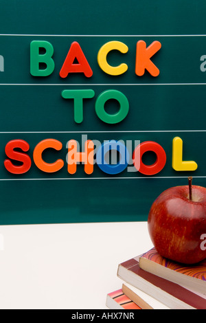 Lavagna con lettere e libri con Apple, visualizzando la frase torna a scuola. Foto Stock
