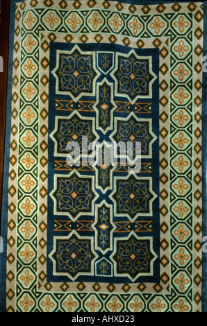 Tappeto tradizionale tibetano caratterizzato da intricati motivi geometrici, stelle a otto punte e motivi floreali in tonalità blu navy, marrone e arancione terra. Foto Stock