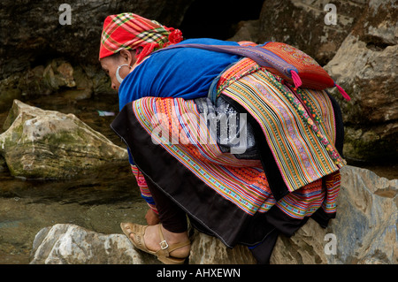 Le donne dal fiore Hmong Trlbe Hill, bere da un flusso, sul suo modo di mercato, Coc Li Mercato, vicino a SAPA, Vietnam Foto Stock