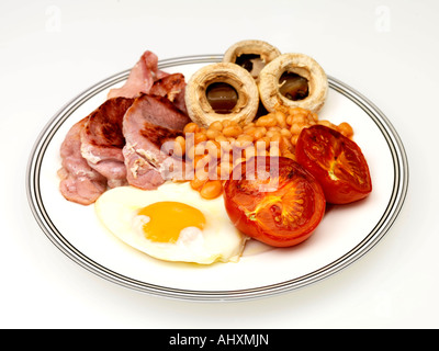 Una sana tradizionale prima colazione inglese con pancetta uovo fritto funghi alla griglia e pomodori isolata contro uno sfondo bianco con tracciato di ritaglio Foto Stock