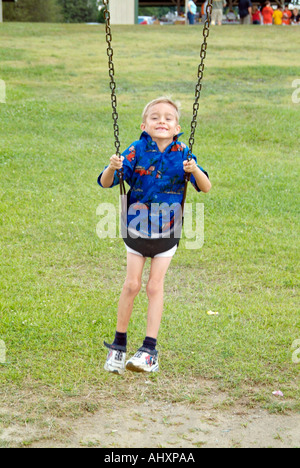 Sette anni di vecchio ragazzo gioca su uno swing Foto Stock