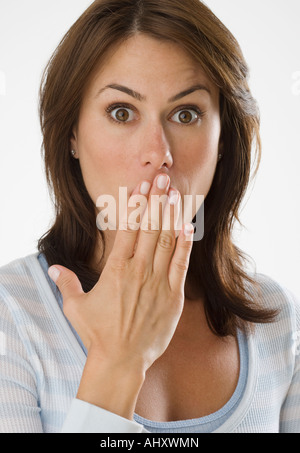 Donna che guarda sorpreso con la mano sulla bocca Foto Stock