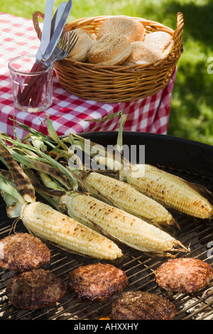 Il mais e hamburger per la cottura sulla griglia Foto Stock