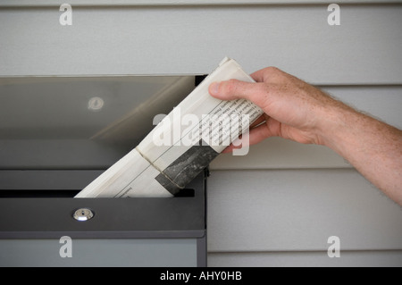 Consegna del giornale persona offrendo quotidiani Foto Stock