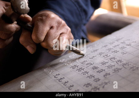 Una minoranza di Dong uomo carving calligrafia su una lastra di pietra in Chengyang provincia di Guangxi in Cina 2005 Foto Stock